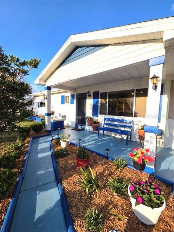 A blue-painted walkway leads to a covered porch with a blue bench and potted flowers — 10957 SW 79TH TERRACE, OCALA, FL