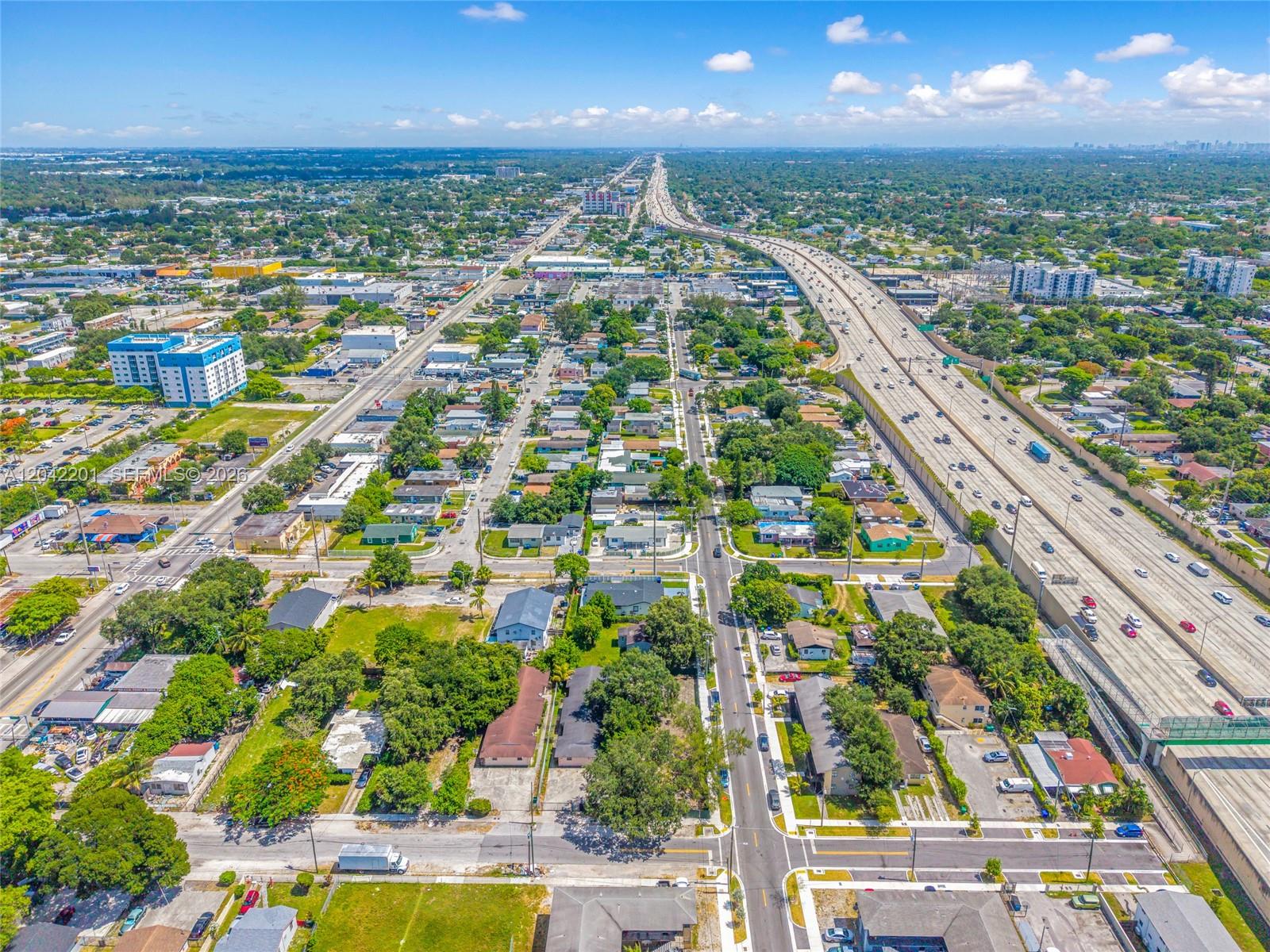 An aerial view shows a residential neighborhood adjacent to a multi-lane highway — 605 NW 65th St, Miami FL 33150, MIAMI, FL
