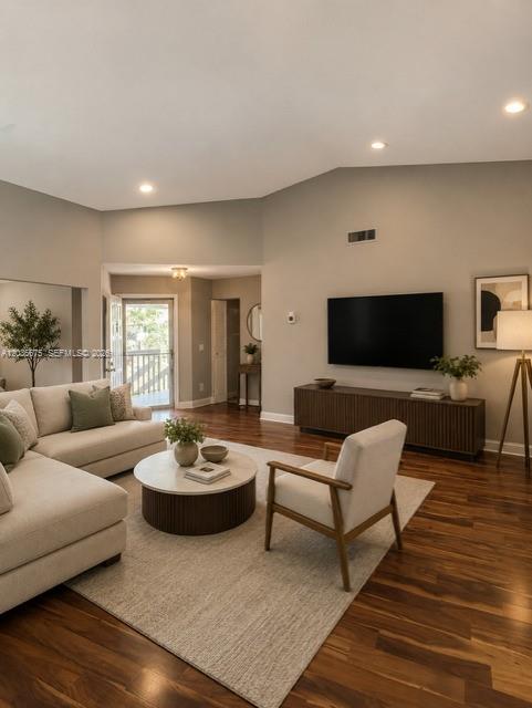 A living room features a sectional sofa, an armchair, a television, and hardwood flooring — 3380 Lucerne Park Dr # 4B, Green Acres FL 33467, GREEN ACRES, FL