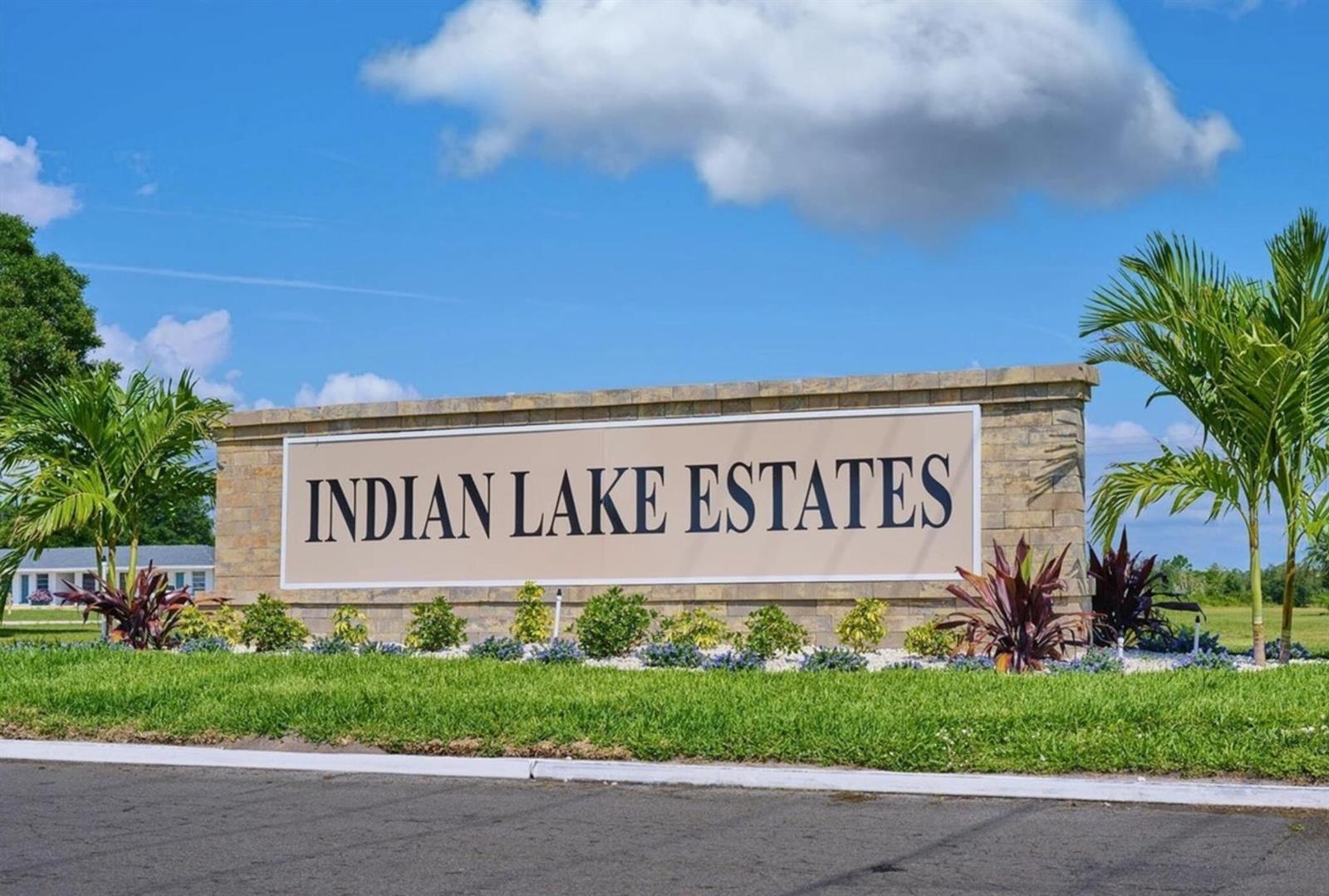 A stone monument sign with the text Indian Lake Estates sits in a grassy area — 1015 Calendula Drive, FL 33855, FL