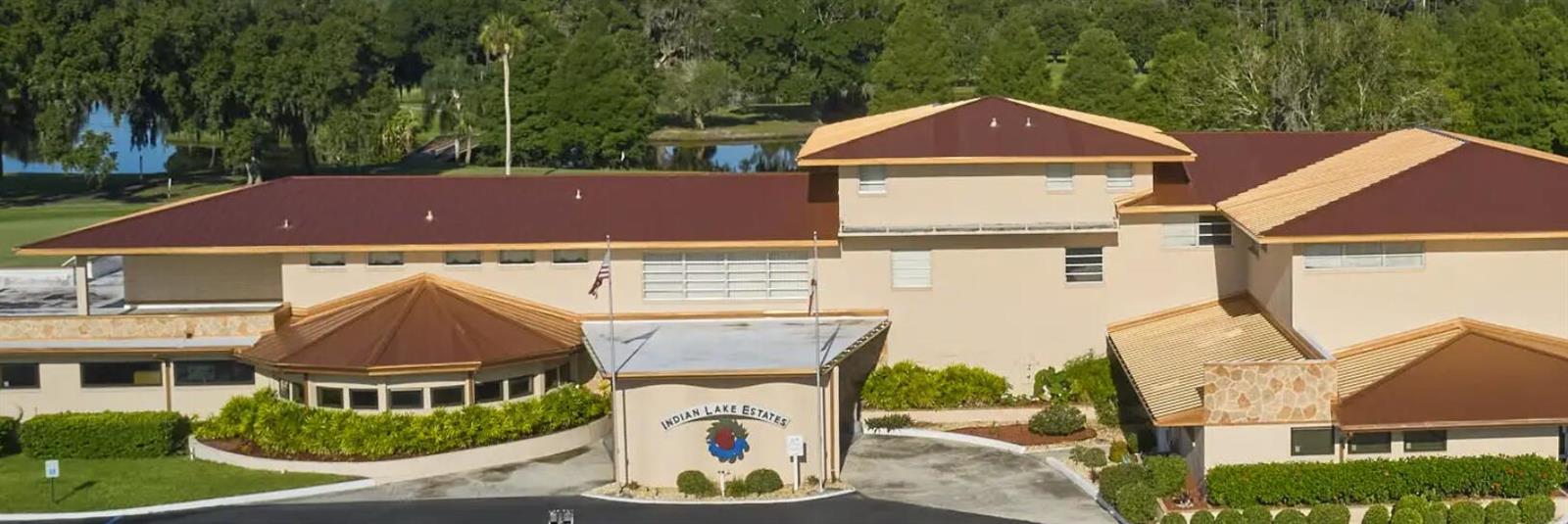 An aerial view of a large, multi-story building with a brown roof and circular entrance — 1015 Calendula Drive, FL 33855, FL
