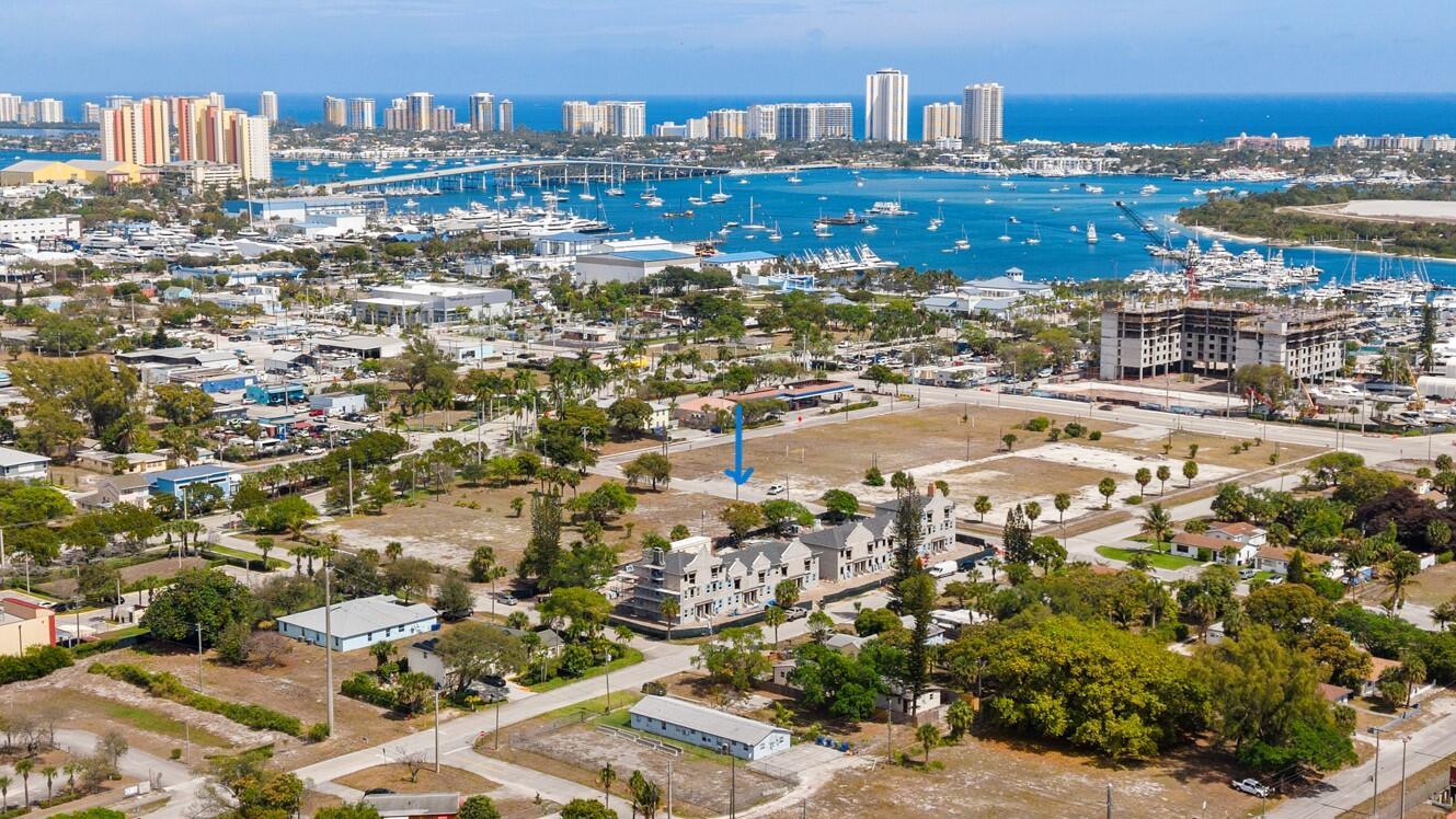 An aerial view shows a vacant lot with a blue arrow pointing toward a white car — 1102 W 11th Street, Riviera Beach FL 33404, RIVIERA BEACH, FL
