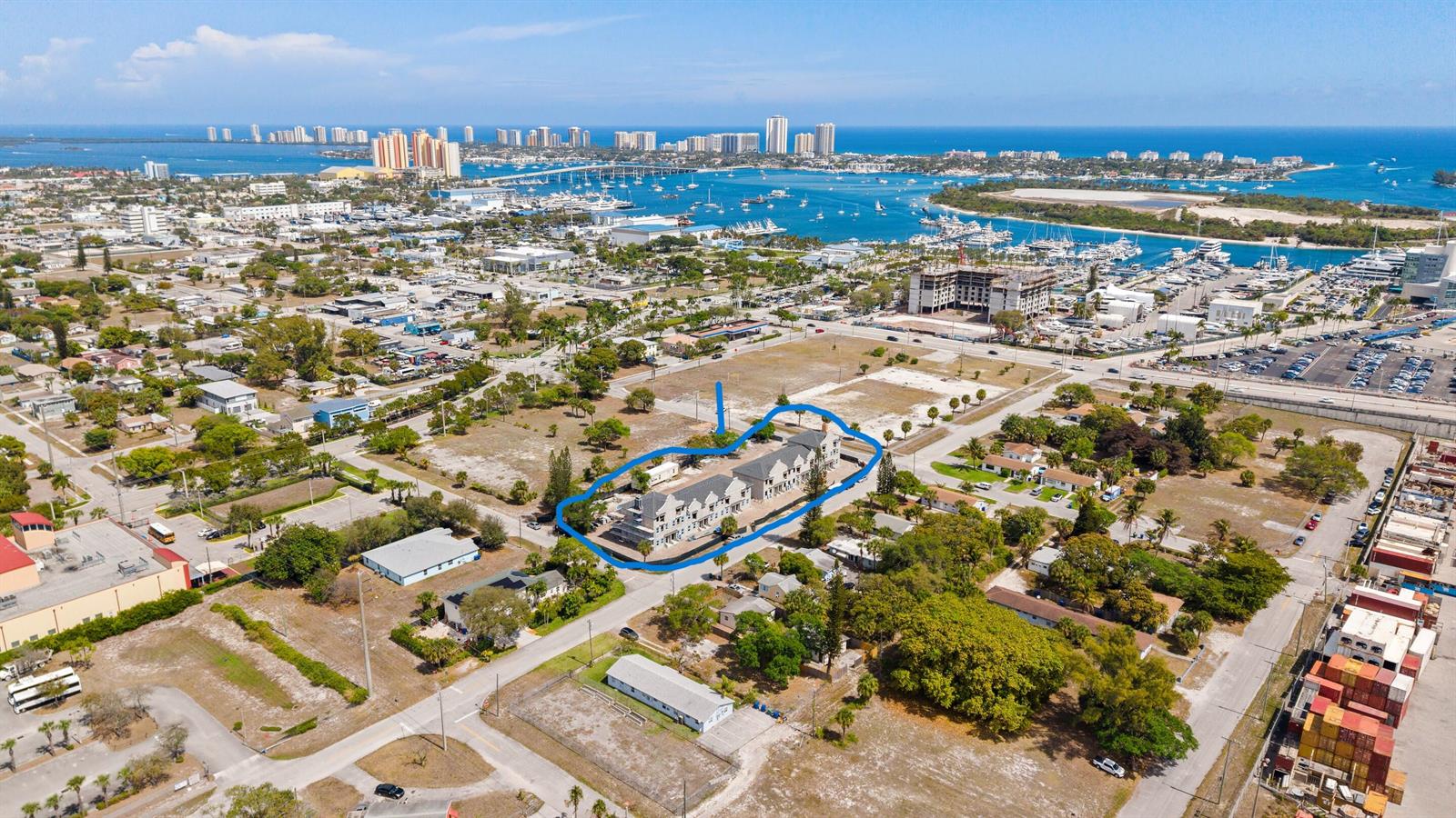 Aerial view of a multi-unit residential building surrounded by vacant lots and coastal city infrastructure — 1102 W 11th Street, Riviera Beach FL 33404, RIVIERA BEACH, FL