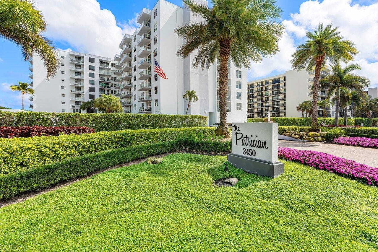 A white high-rise apartment building stands behind a landscaped lawn with a prominent entrance sign — 3450 S Ocean Boulevard # 5010, Palm Beach FL 33480, PALM BEACH, FL