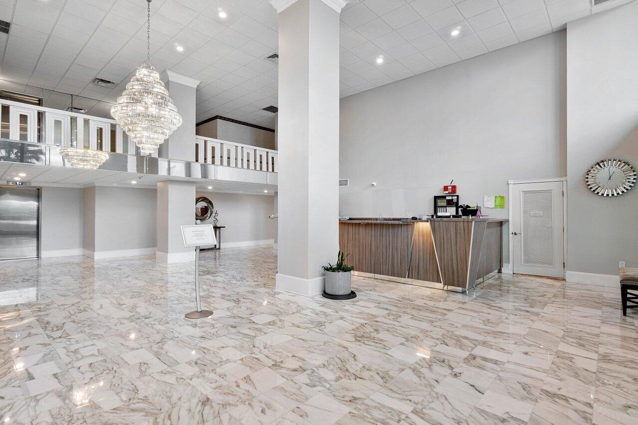 A spacious hotel lobby features marble flooring, a large crystal chandelier, and a reception desk — 3450 S Ocean Boulevard # 5010, Palm Beach FL 33480, PALM BEACH, FL