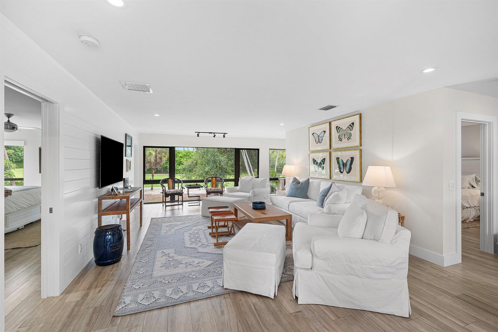 A bright living room features white furniture, a patterned area rug, and large windows — 4285 B Quail Ridge Drive N, Boynton Beach FL 33436, BOYNTON BEACH, FL