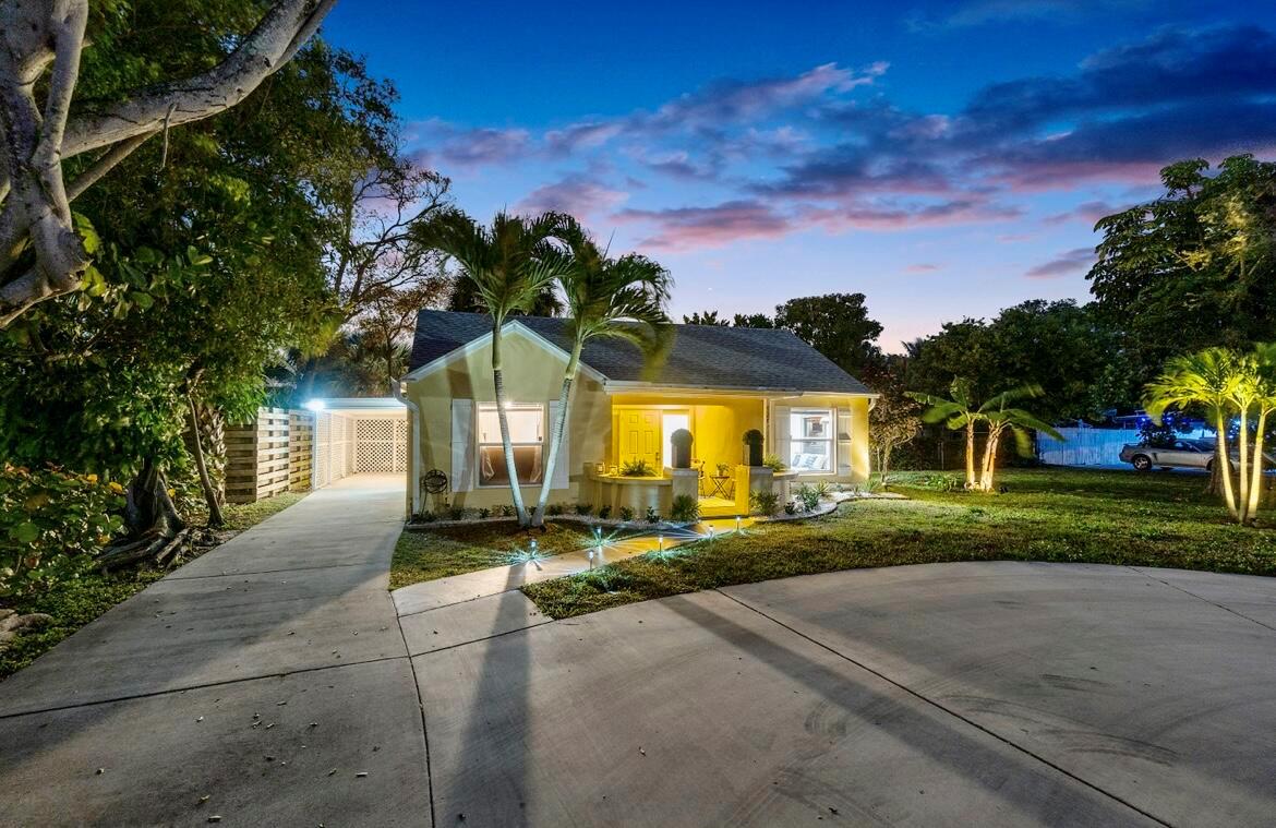 A yellow single-story house with a concrete driveway, palm trees, and a covered carport — 727 S Lake Drive, Lantana FL 33462, LANTANA, FL