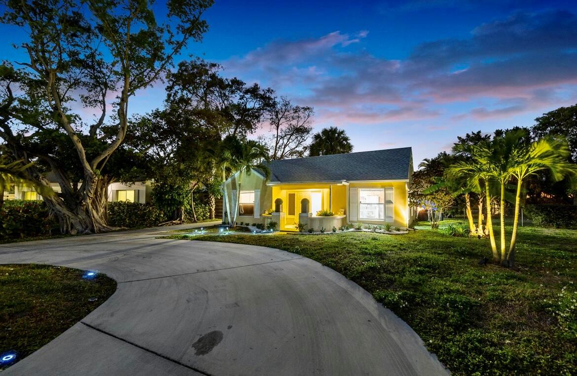 A yellow single-story house with a curved driveway and palm trees at twilight — 727 S Lake Drive, Lantana FL 33462, LANTANA, FL