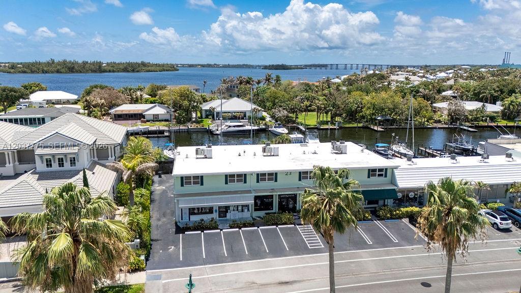 An aerial view shows a two-story commercial building with a parking lot and boat slips — 23 Royal Palm Pt # B, Vero Beach FL 32960, VERO BEACH, FL