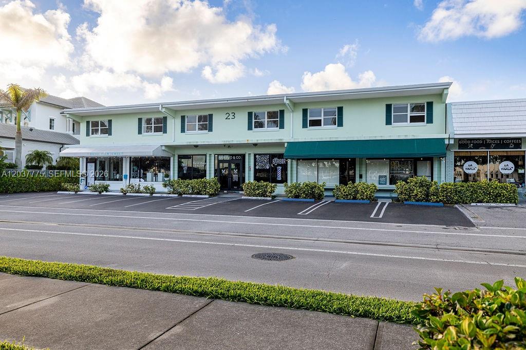 A two-story light green commercial building features multiple storefronts with awnings and a parking lot — 23 Royal Palm Pt # B, Vero Beach FL 32960, VERO BEACH, FL