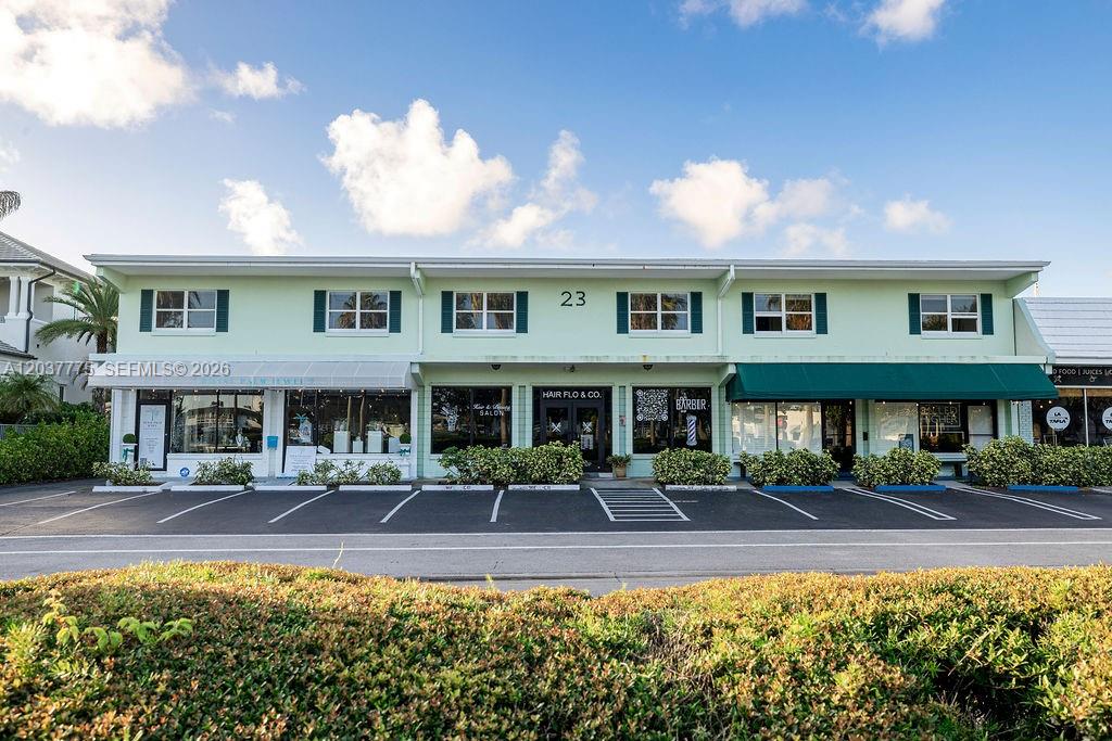 A two-story light green commercial building with multiple storefronts and a parking lot in front — 23 Royal Palm Pt # B, Vero Beach FL 32960, VERO BEACH, FL