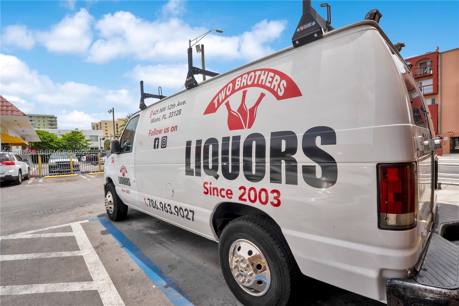 A white Two Brothers Liquors delivery van is parked in a paved parking lot — 425 NW 12th ave suite j-k, Miami FL 33128, MIAMI, FL