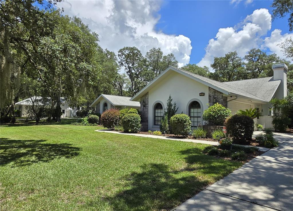 A single-story house with a white exterior, arched windows, and a large front lawn — 244 W MASSACHUSETTS STREET, HERNANDO, FL