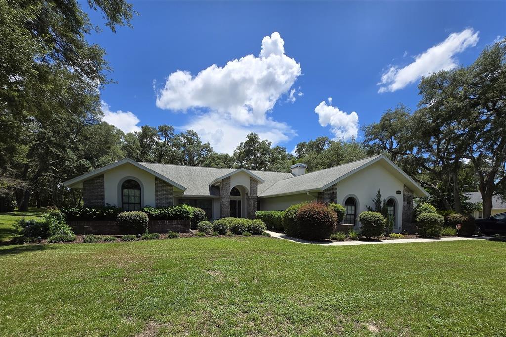 A single-story house with a brick and stucco exterior sits on a grassy lawn — 244 W MASSACHUSETTS STREET, HERNANDO, FL