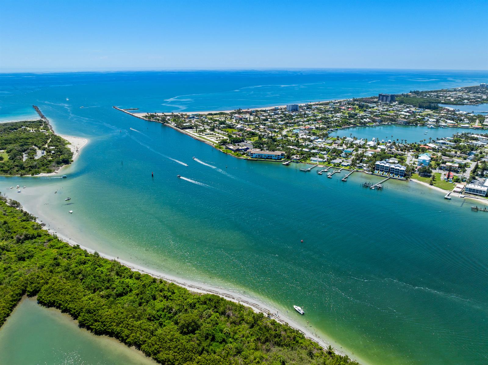 An aerial view shows a coastal inlet with boats, sandy beaches, and residential waterfront properties — 1404 Binney Drive, Fort Pierce FL 34949, FORT PIERCE, FL