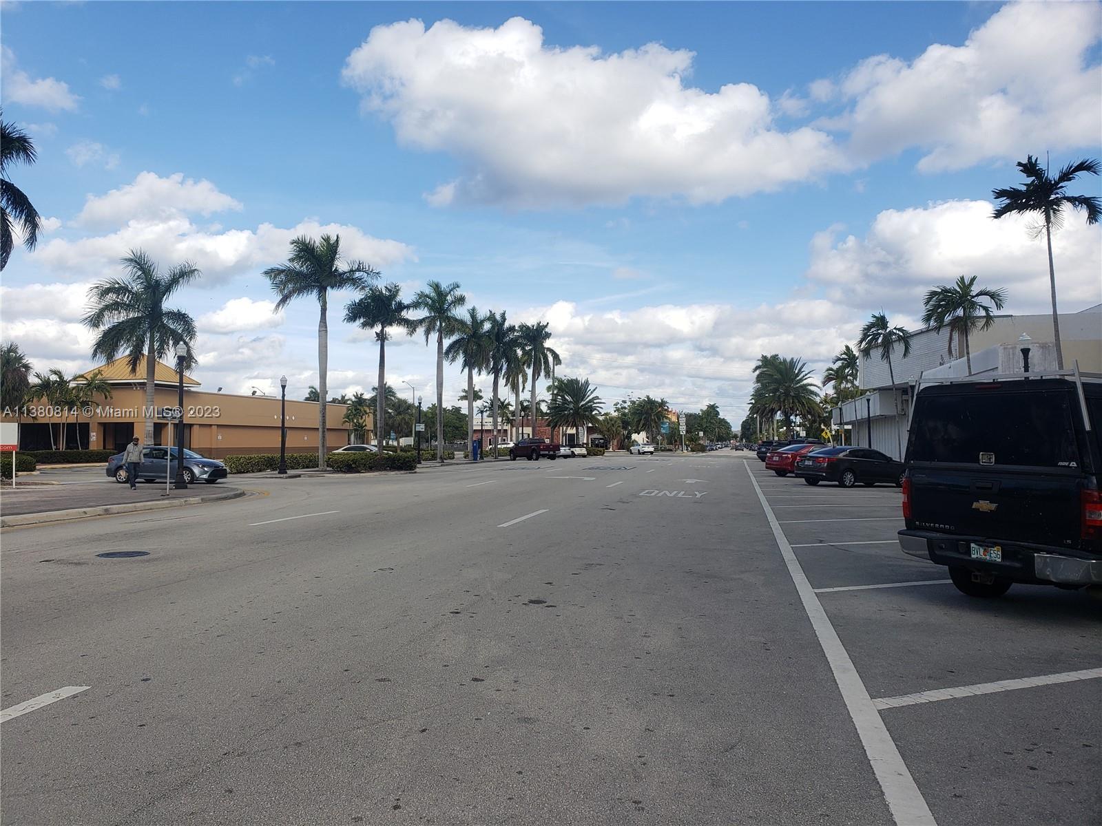 A street view shows a multi-lane road lined with palm trees and parked cars — 1720 Harrison St # 12D, Hollywood FL 33020, HOLLYWOOD, FL