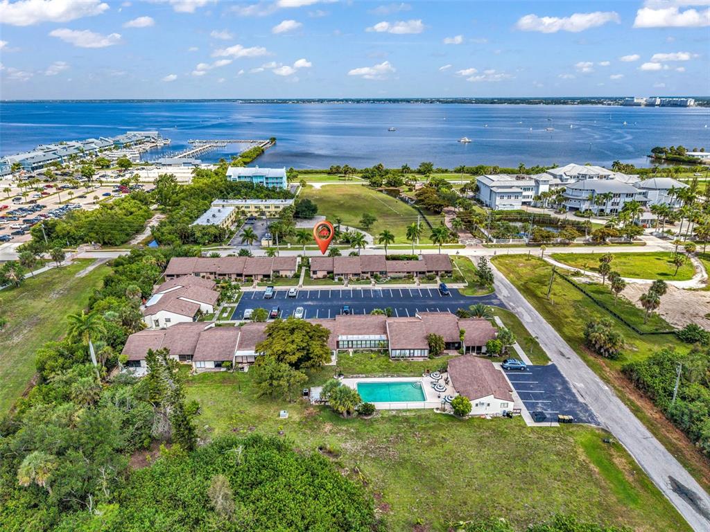 An aerial view shows a residential complex with a swimming pool near a large bay — 1001 W MARION AVENUE UNIT 5, PUNTA GORDA, FL