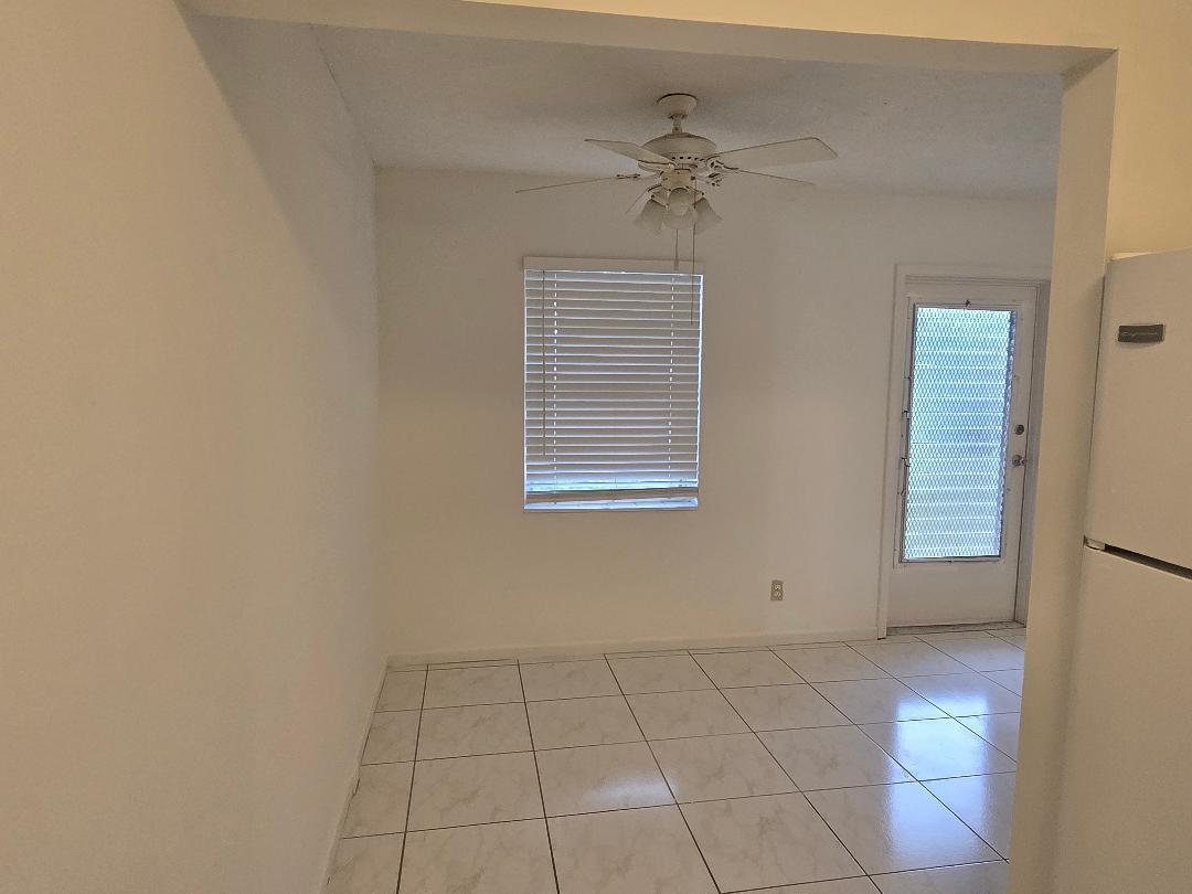 A dining area features white tile flooring, a ceiling fan, and a window with blinds — 227 Kent N, West Palm Beach FL 33417, WEST PALM BEACH, FL