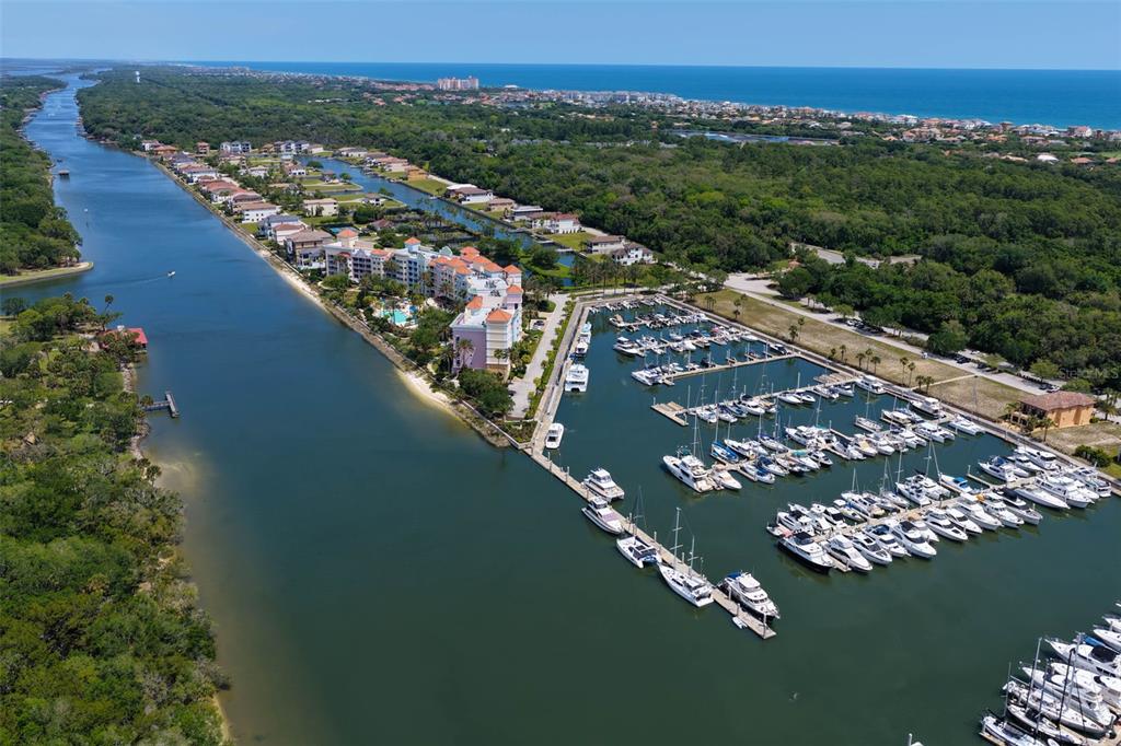 An aerial view shows a marina with numerous docked boats next to a large residential complex — 102 YACHT HARBOR DRIVE UNIT 371, PALM COAST, FL