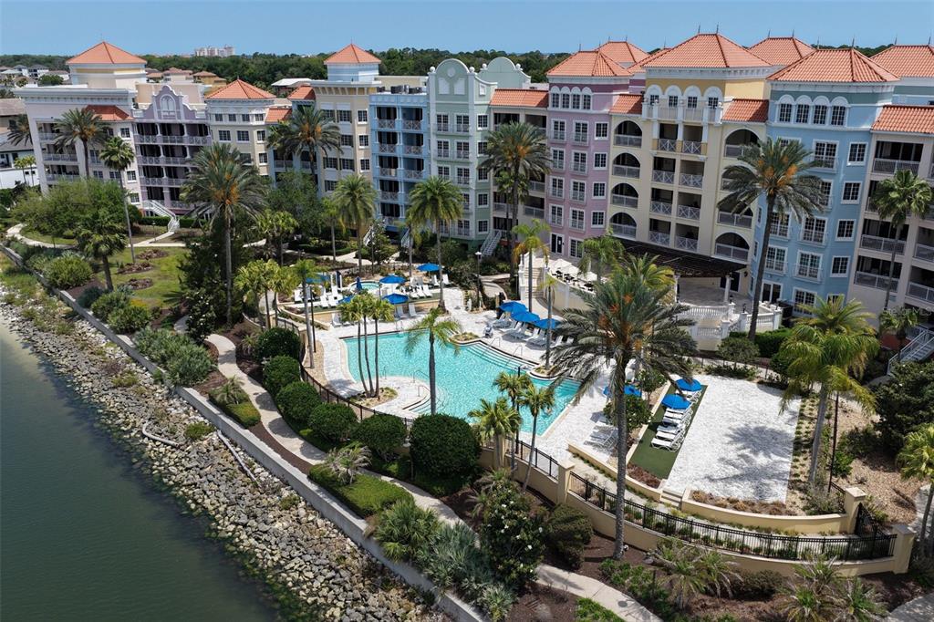 An aerial view of a multi-story apartment complex with a pool and palm trees — 102 YACHT HARBOR DRIVE UNIT 371, PALM COAST, FL