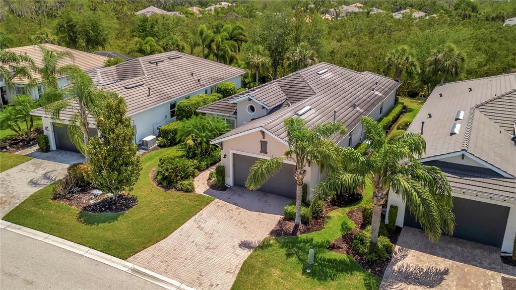 An aerial view shows three suburban houses with tiled roofs and palm trees in Florida — 5009 LAKE OVERLOOK AVENUE, BRADENTON, FL
