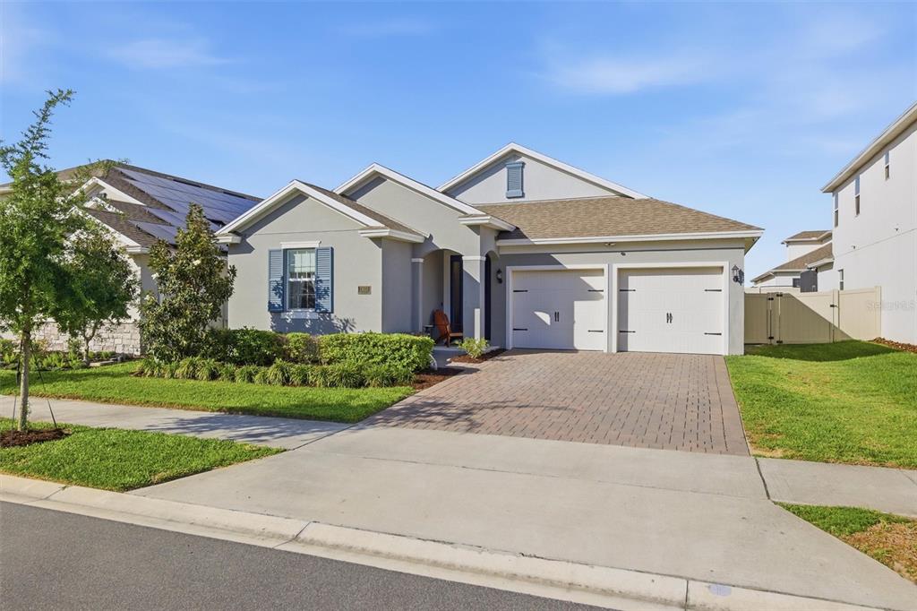 A single-story suburban house with a gray exterior, a two-car garage, and a paved driveway — 15033 LAKE BESSIE LOOP, WINTER GARDEN, FL