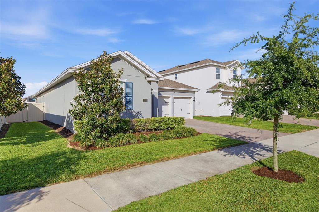 A single-story suburban house with a two-car garage and a paved driveway — 15033 LAKE BESSIE LOOP, WINTER GARDEN, FL