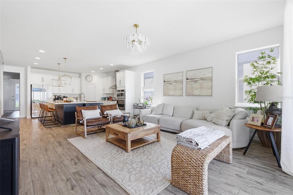 A gray single-story house with a two-car garage sits next to a two-story home — 15033 LAKE BESSIE LOOP, WINTER GARDEN, FL