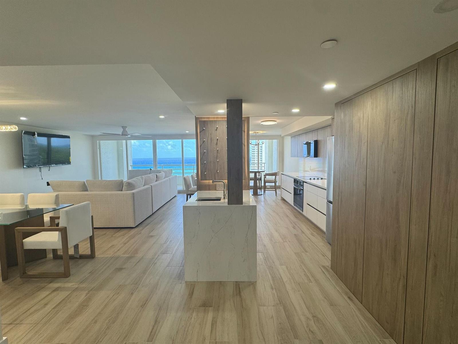 An open-concept living area features a kitchen with a marble island and ocean views — 4201 N Ocean Boulevard # 1407, Boca Raton FL 33431, BOCA RATON, FL