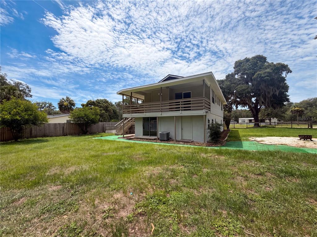 A two-story house with a wooden deck and a large grassy backyard — 22415 HORIZON VISTAS DRIVE, EUSTIS, FL