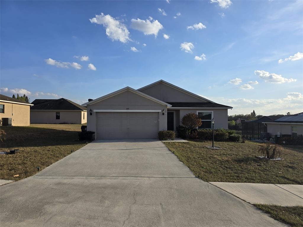 An entryway with white walls, tiled floors, a hanging light fixture, and two closed doors — 326 DINNER LAKE COURT, LAKE WALES, FL