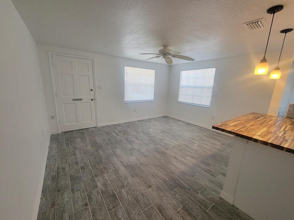 A room with gray wood-look tile flooring, a ceiling fan, and two windows — 4929 FILNER STREET, NEW PORT RICHEY, FL