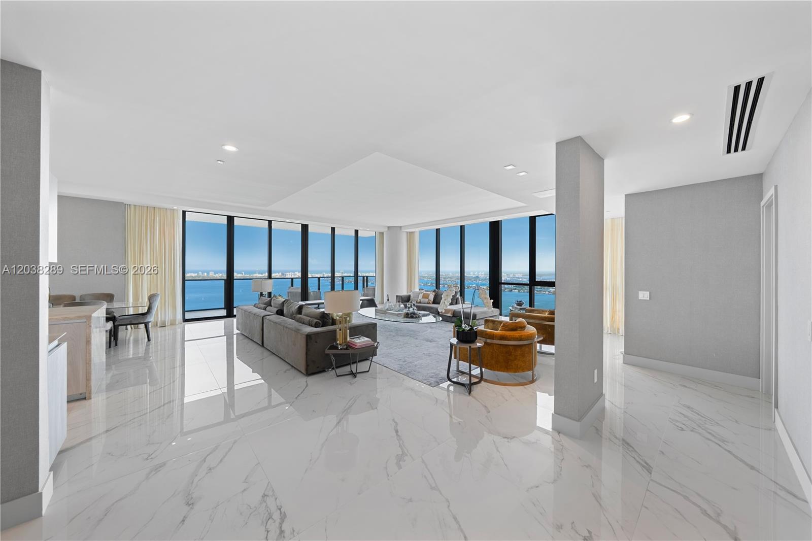 A spacious living room features marble floors, floor-to-ceiling windows, and panoramic ocean views — 3131 NE 7th Ave, Miami FL 33137, MIAMI, FL