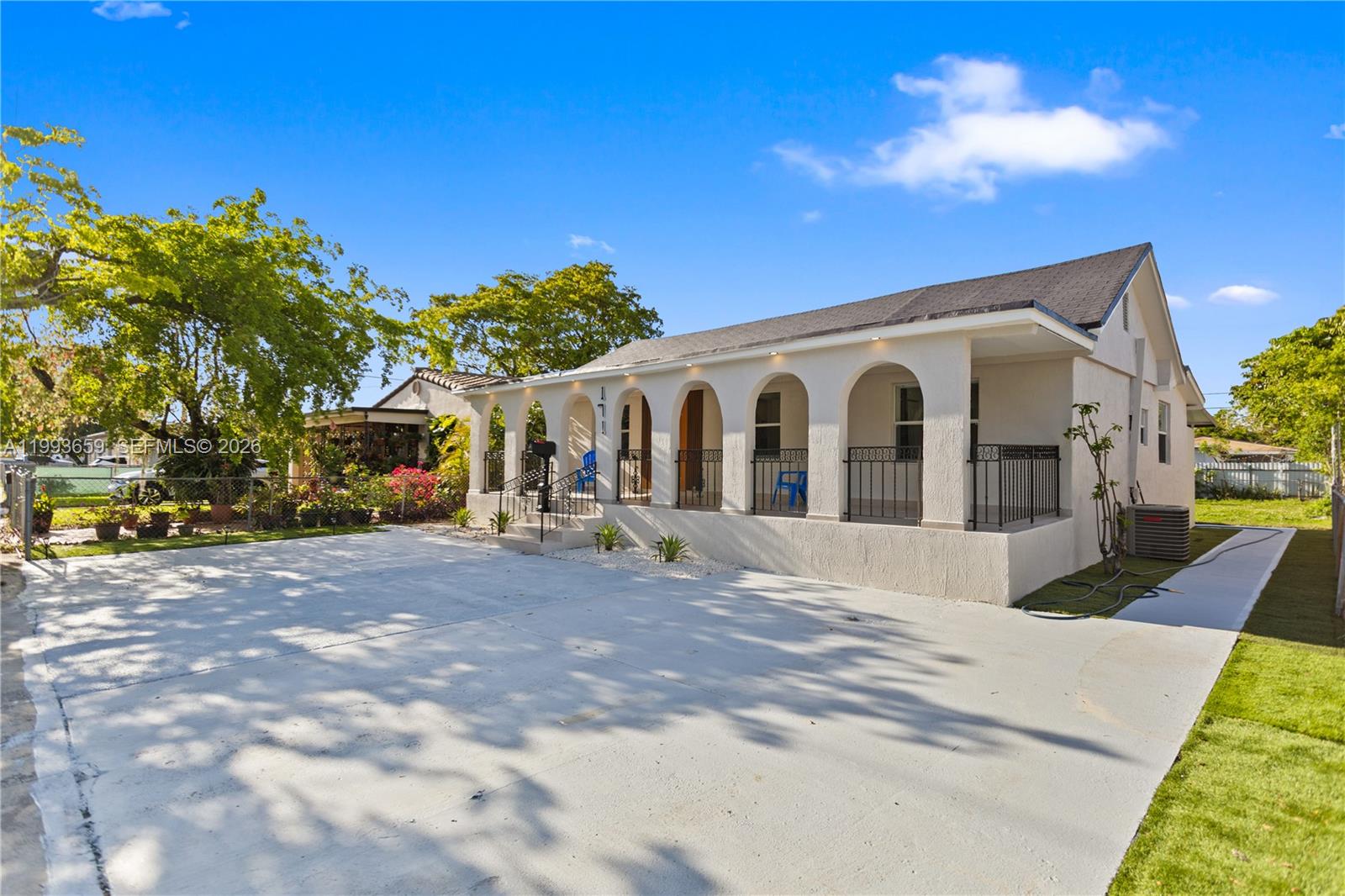 A single-story house features a covered arched porch, a concrete driveway, and a fenced yard — 171 W 13th St, Hialeah FL 33010, HIALEAH, FL