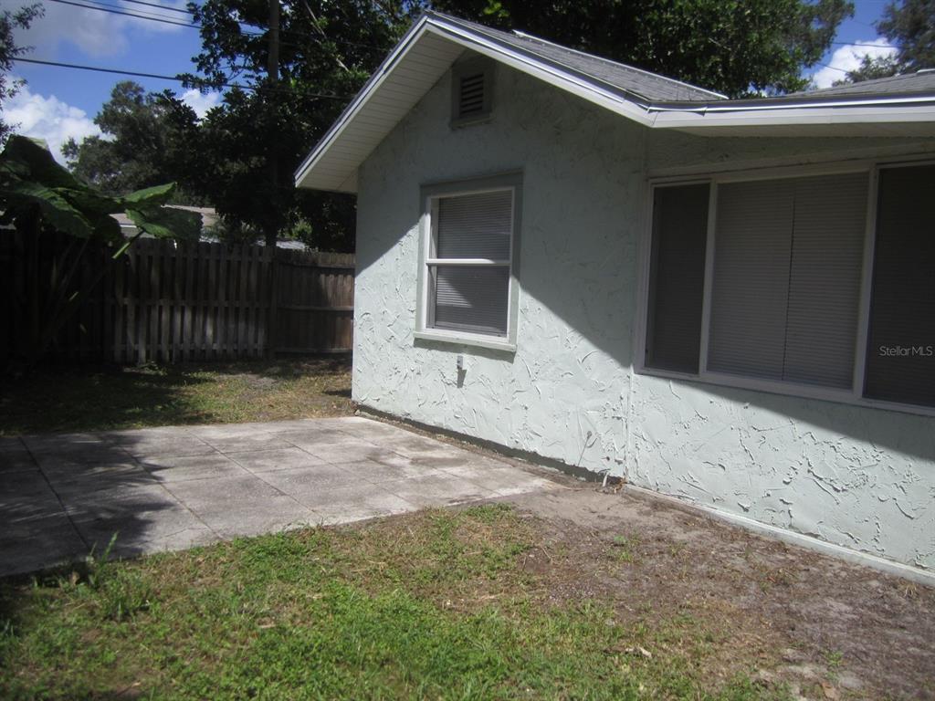 A room with diagonal wood paneling, tile flooring, and an adjacent carpeted living area — 4840 19TH STREET N, ST PETERSBURG, FL