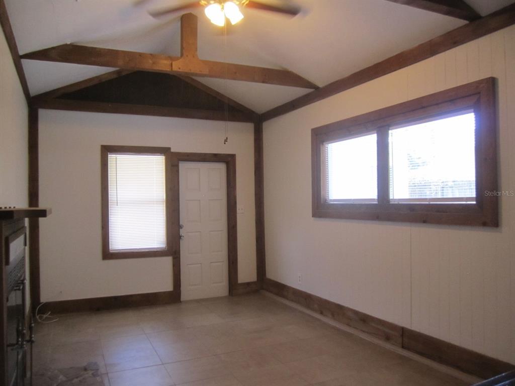 An interior bedroom with brown carpet, white walls, wood trim, and two open doorways — 4840 19TH STREET N, ST PETERSBURG, FL
