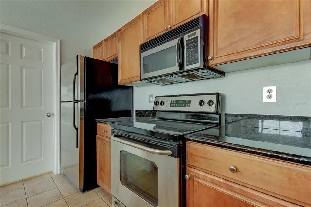 A kitchen features wooden cabinets, stainless steel appliances, and black granite countertops — 700 S HARBOUR ISLAND BOULEVARD UNIT 309, TAMPA, FL