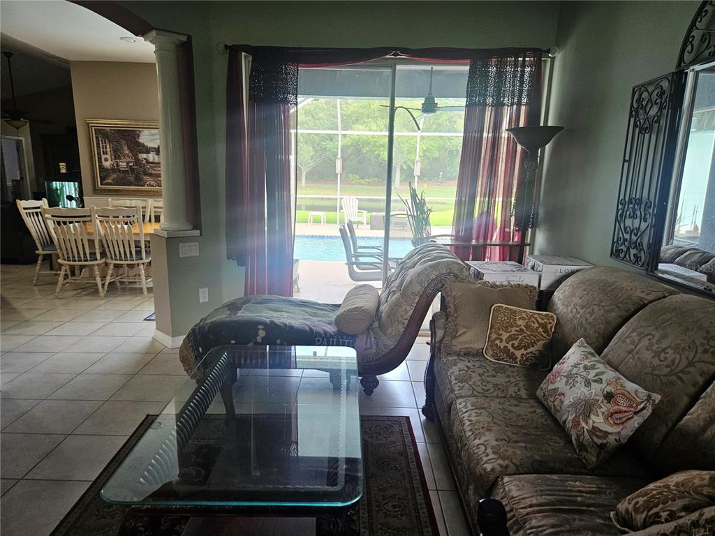 A kitchen features light wood cabinets, granite countertops, a central island, and an adjacent dining area — 14510 CORKWOOD DRIVE, TAMPA, FL