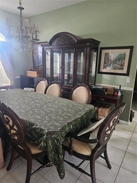 A dining room features a dark wood hutch, a table with a patterned cloth, and chairs — 14510 CORKWOOD DRIVE, TAMPA, FL