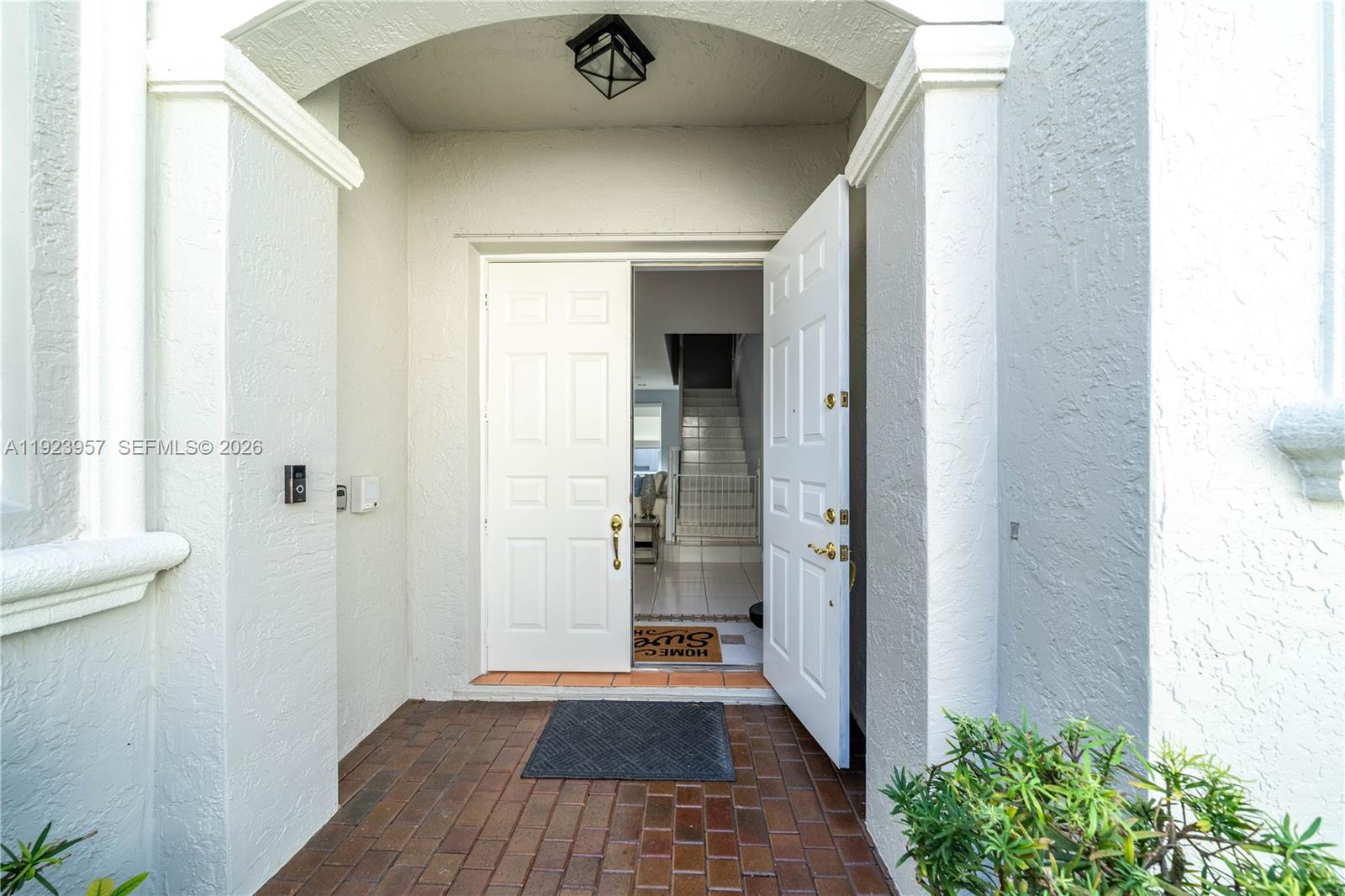 An open double door reveals an entryway with a staircase and tiled flooring — 1547 Mariner Way, Hollywood FL 33019, HOLLYWOOD, FL