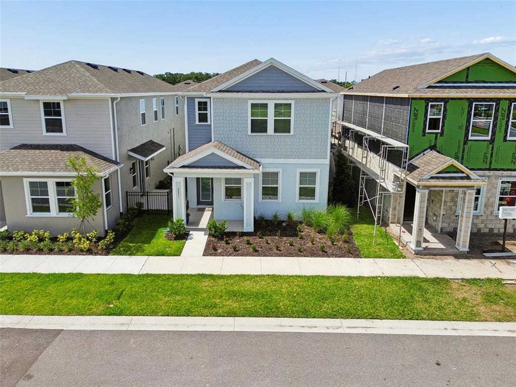 A modern kitchen with white cabinets, a large island, and an open-concept dining and living area — 2021 AMELIA BAY PLACE, VALRICO, FL