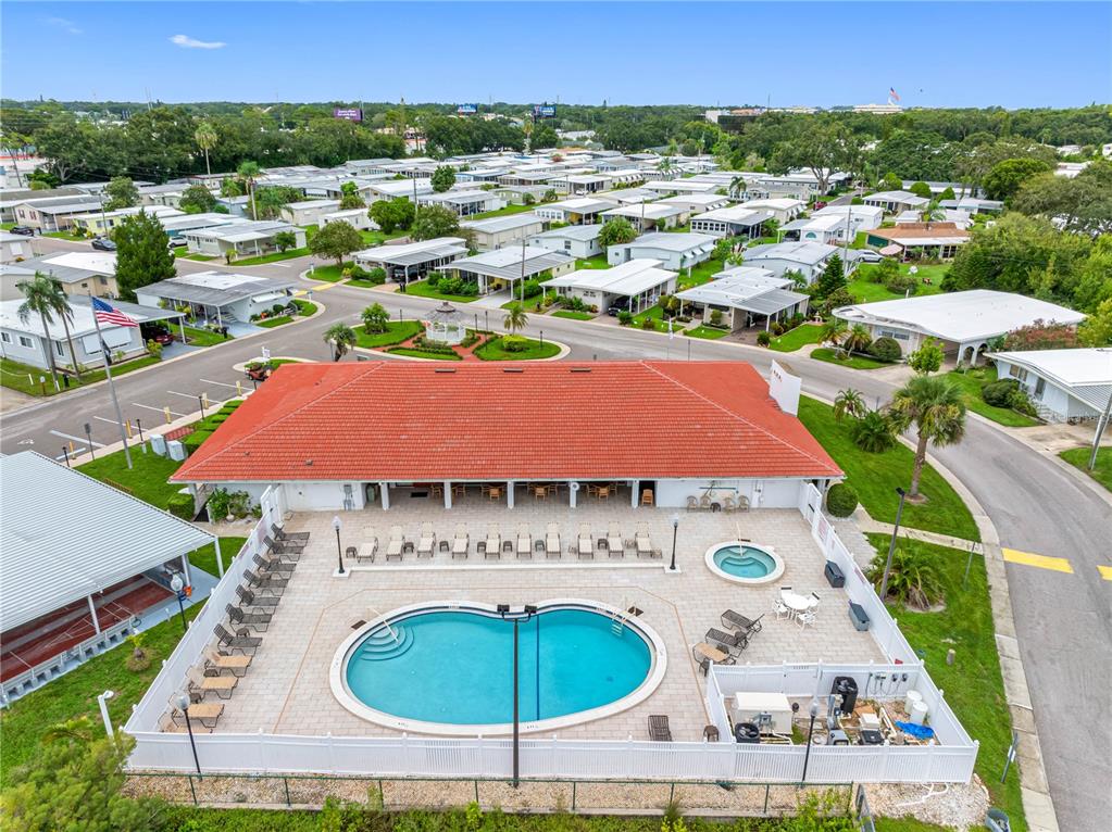 An aerial view shows a community clubhouse with a swimming pool and hot tub — 29250 US HIGHWAY 19 N UNIT 578, CLEARWATER, FL