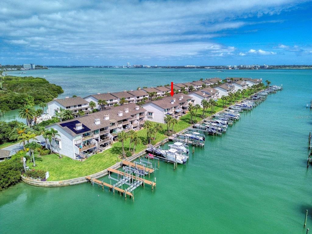An aerial view shows a waterfront condominium complex with private boat slips and docks — 119 MARINA DEL REY COURT, CLEARWATER BEACH, FL