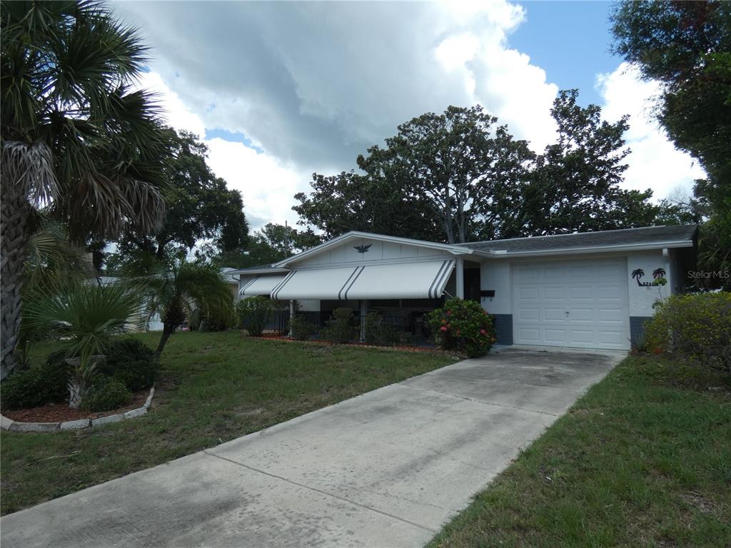 A single-story house with a white garage, a covered front porch, and a concrete driveway — 5248 IRONWOOD LANE, NEW PORT RICHEY, FL
