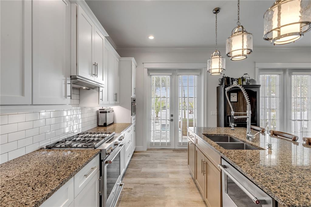 A kitchen features white cabinets, granite countertops, a gas range, and a central island — 4636 SAXON DRIVE, NEW SMYRNA BEACH, FL