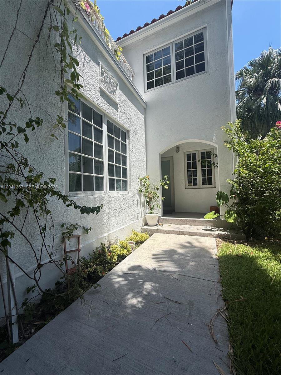 A white stucco house exterior features a concrete walkway leading to a recessed entryway — 912 Euclid Ave, Miami Beach FL 33139, MIAMI BEACH, FL