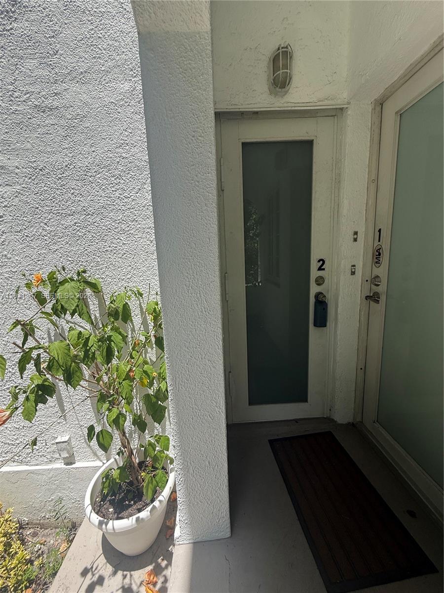 An exterior view shows a white door labeled number two with a potted plant nearby — 912 Euclid Ave, Miami Beach FL 33139, MIAMI BEACH, FL