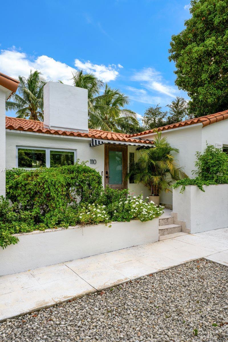 The exterior of a white stucco house features a red tile roof and landscaping — 1110 NW North River Dr, Miami FL 33136, MIAMI, FL