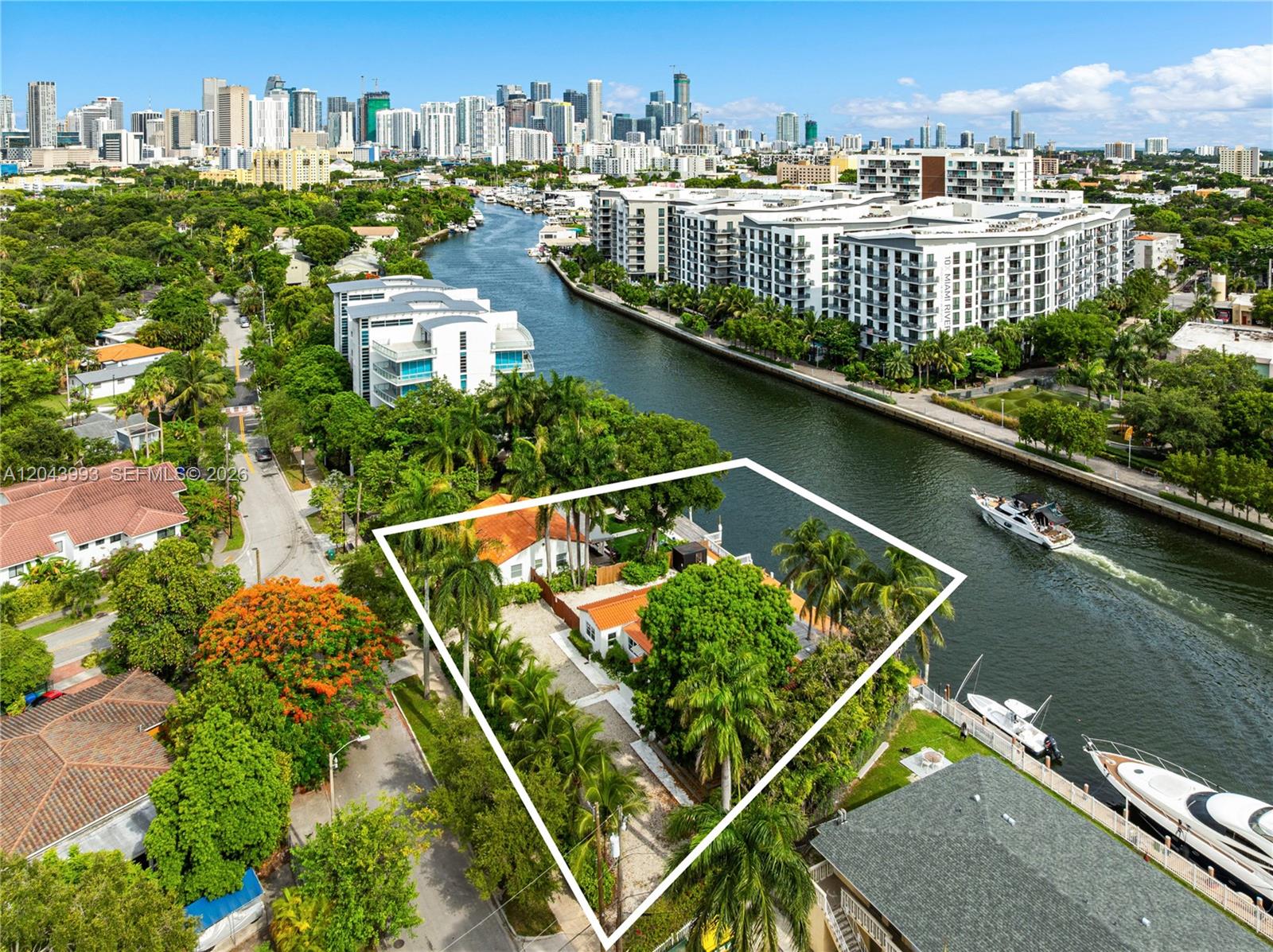 An aerial view shows a waterfront property with a white house and palm trees — 1110 NW North River Dr, Miami FL 33136, MIAMI, FL