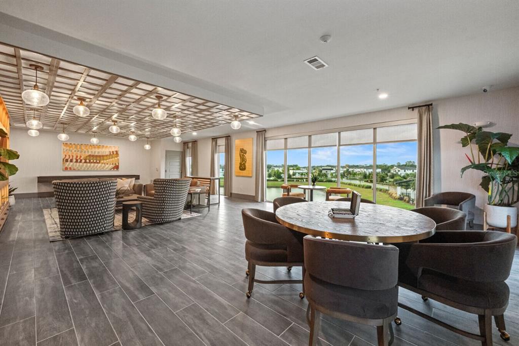 A spacious lounge area features a wooden ceiling grid, tile flooring, and large window views — 6000 PARADISO GRANDE BOULEVARD UNIT B2, ORLANDO, FL